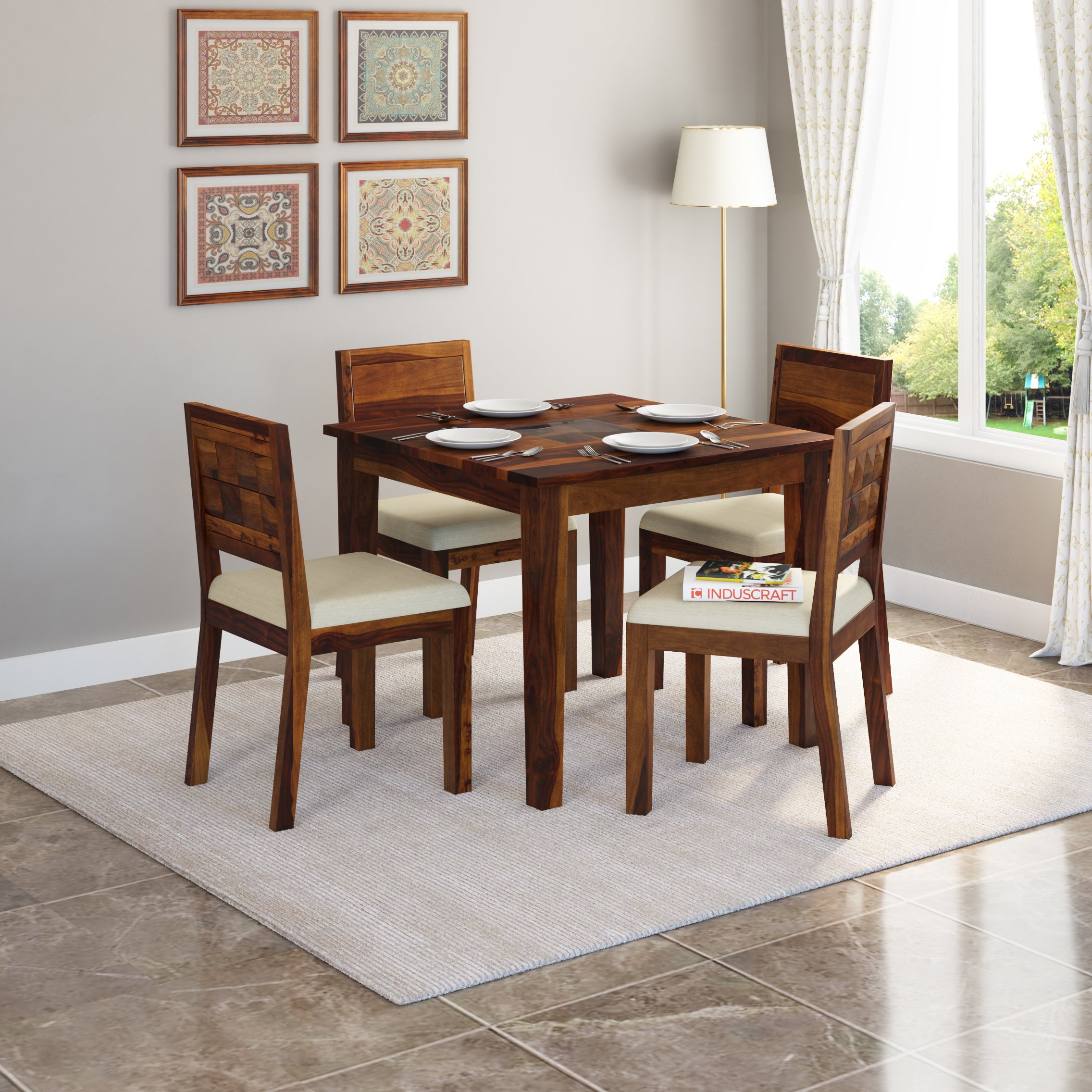 A solid Sheesham wood dining table with four chairs around it, placed on a rug in a room with decorative curtains and a lamp on the side.