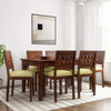 Dining room with wooden table and chairs with yellow cushions.