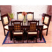 Dining table set with chairs on a patterned rug in a room with blinds.