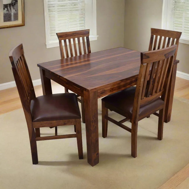 Wooden dining table with four matching chairs in a room setting.