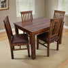 Wooden dining table with four matching chairs in a room setting.