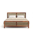 Wooden bed with wicker headboard and footboard on a white background