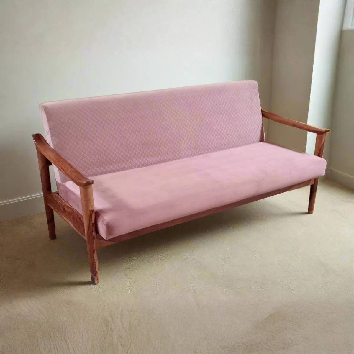 Pink sofa with wooden frame in a room with beige carpet and white walls