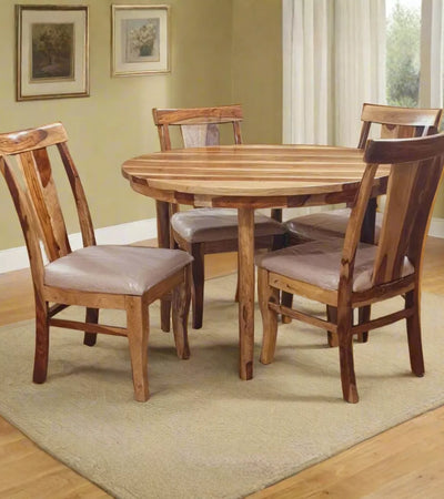 Wooden dining table with four chairs in a room with light green walls and a window.