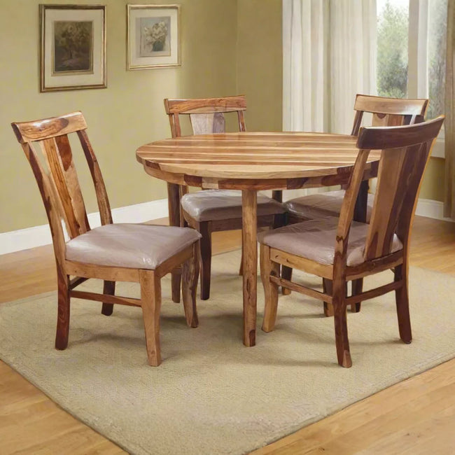 Wooden dining table with four chairs in a room with light green walls and a window.