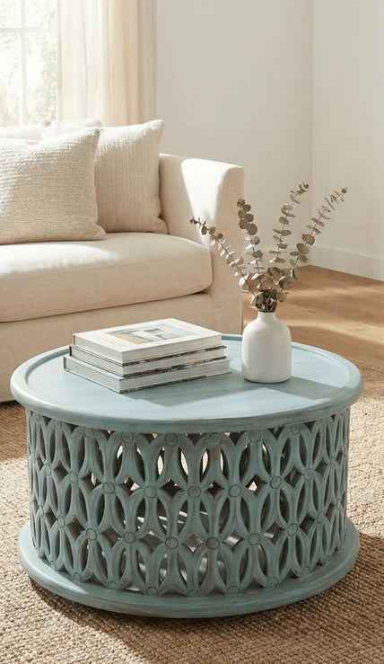 Aarav carved round coffee table in blue distressed finish in a living room