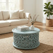 Aarav carved round coffee table in blue distressed finish in a living room