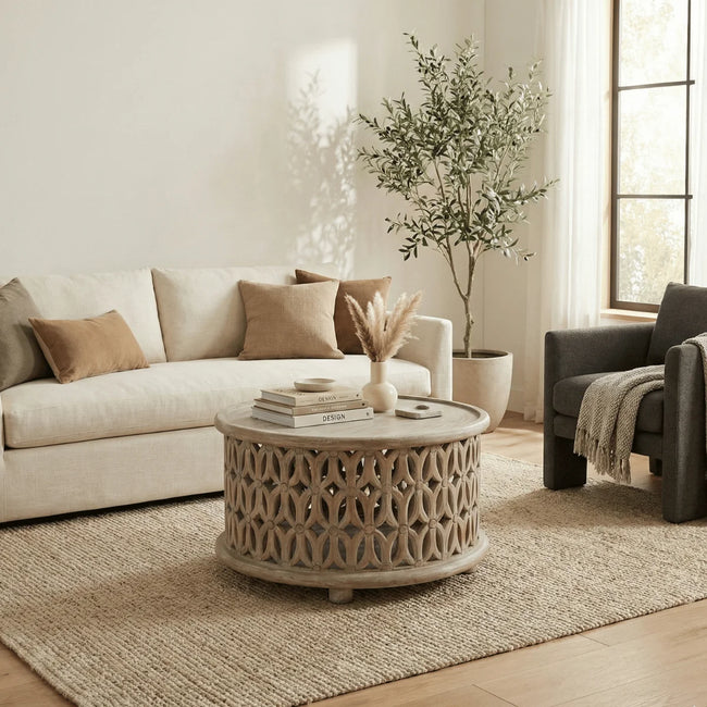 Aarav carved round coffee table in white distressed finish in a living room