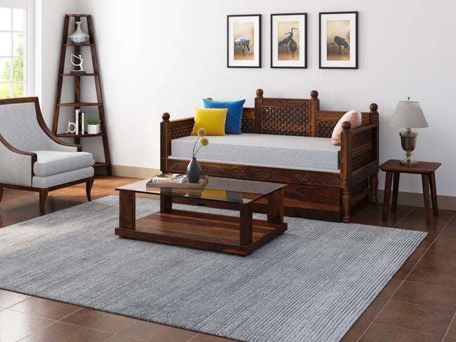 Aeron glass top sheesham coffee table in front of a wooden sofa