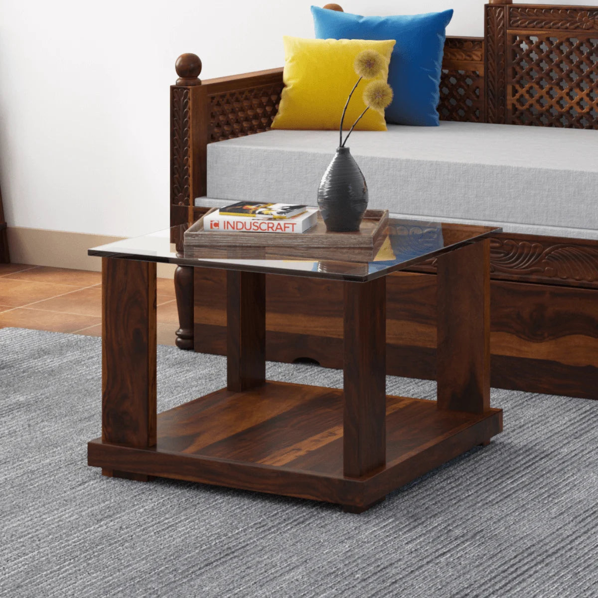 Aeron small square sheesham wood coffee table with glass top in a living room