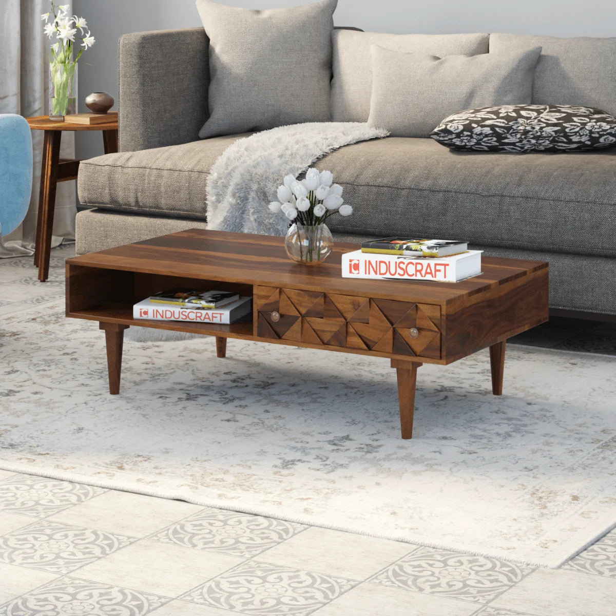 Ashley rectangular carved sheesham wood coffee table with drawer and shelf in a living room