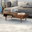 Ashley rectangular carved sheesham wood coffee table with drawer and shelf in a living room