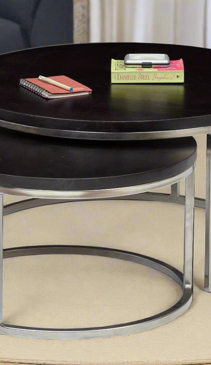 Axton round nesting coffee tables set of 2 with wood top and silver iron base in a living room