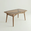 Brendon solid wood dining table with glass top in rectangular design and tapered legs.