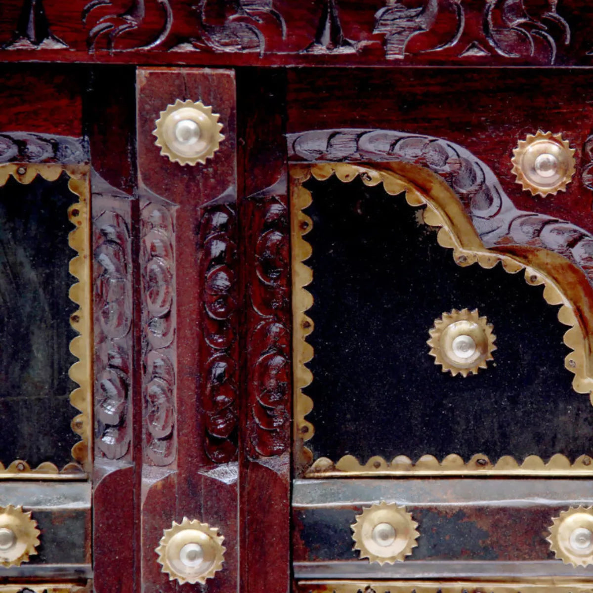 Close-up of carved arches and brass studs on Rajasthani door panel center table