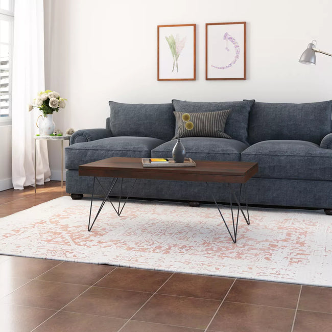 Kiana sheesham coffee table with hairpin metal legs in front of a blue sofa