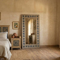 Meher Heritage hand-carved teak wood full length floor mirror with intricate blue tile border frame in a rustic bedroom setting