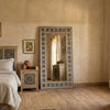 Meher Heritage hand-carved teak wood full length floor mirror with intricate blue tile border frame in a rustic bedroom setting