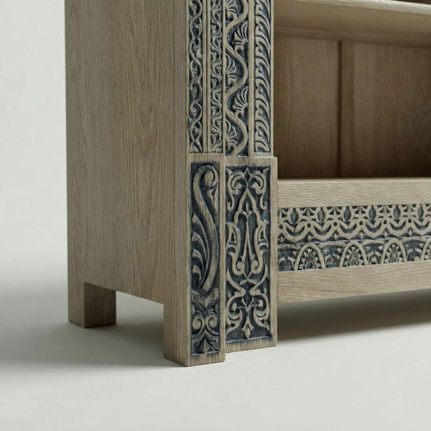 Closeup view of Meher rustic teak wood hand-carved display cabinet emphasizing light wood shelves and carved pedestal base