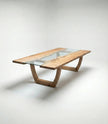 Nolan solid wood glass top dining table with rectangular design and curved wooden base.