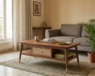 Solid wood rectangular coffee table with cane drawer and brass capped legs in a living room